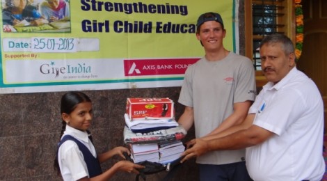 Dr. Anil Abbi handing out books  and stationary to girls at TRDC's remedial education center at Ranibennur.
