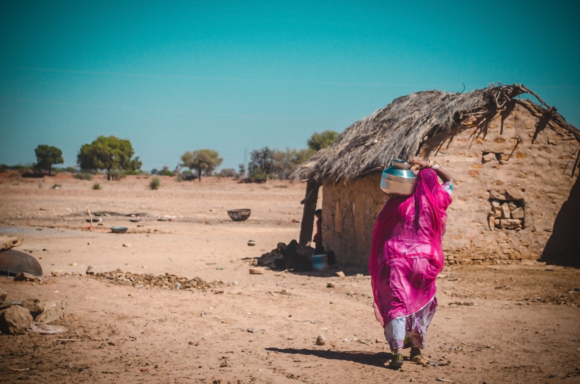 a woman in an indian village carrying a water pot