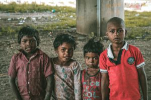 four poor indian children standing together