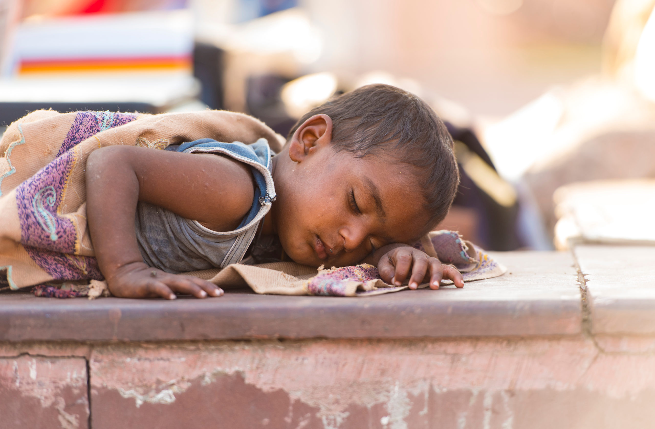 an orphan child sleeping outdoors