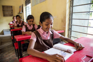 Girls in India studying in their classrooms with a smile on their faces