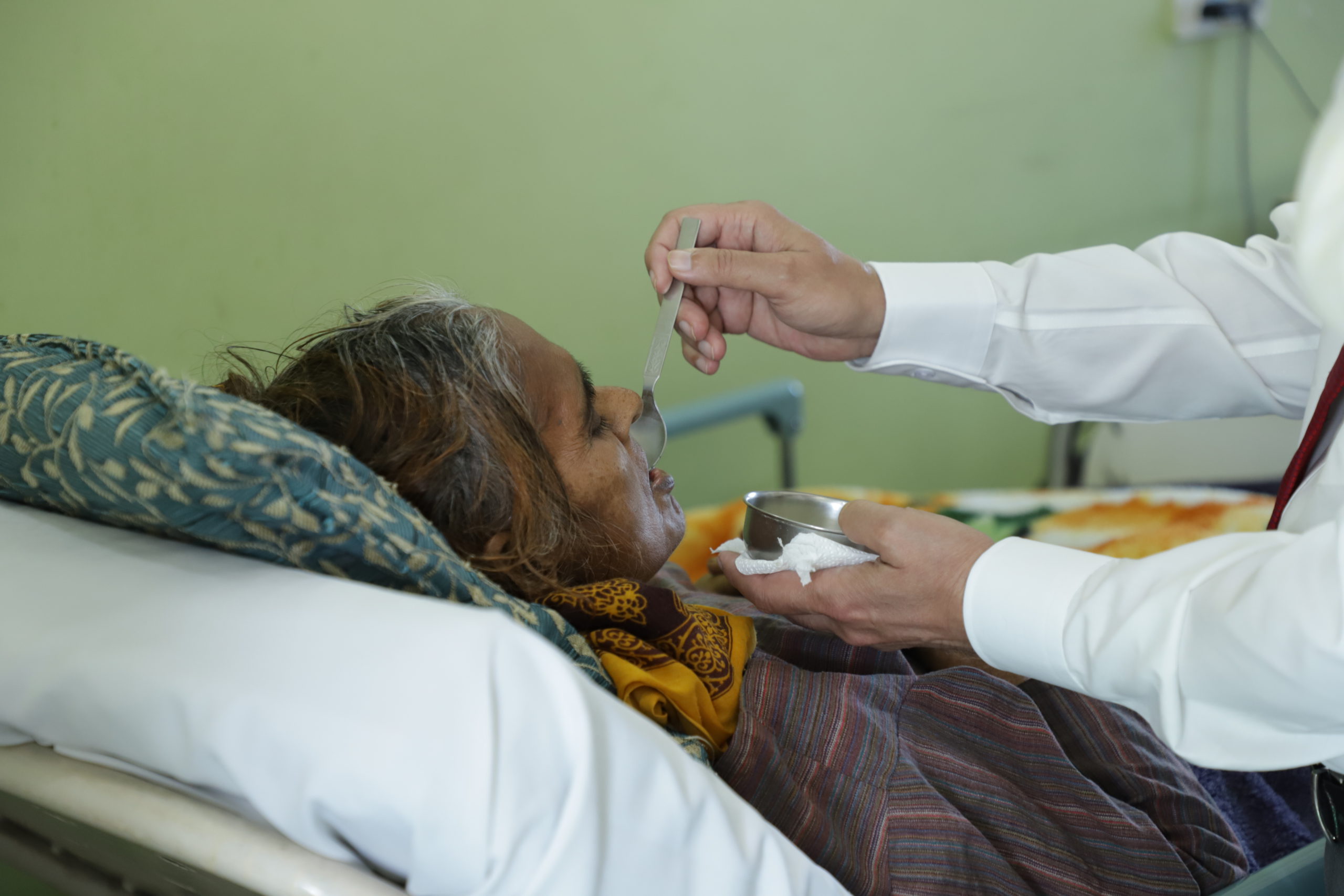 a cancer patient being fed by a caregiver