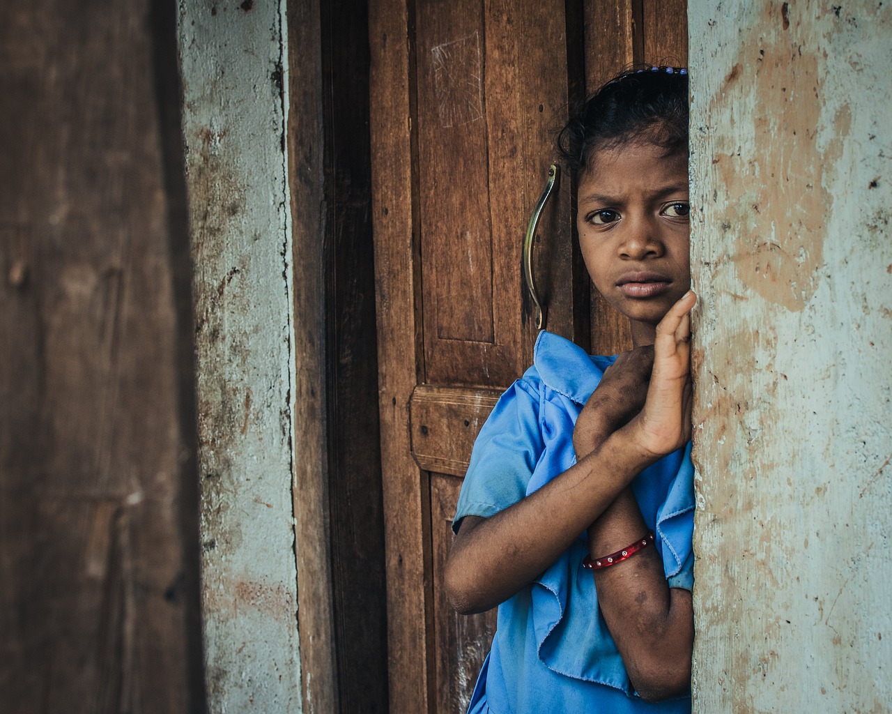 A girl in India standing next to a door