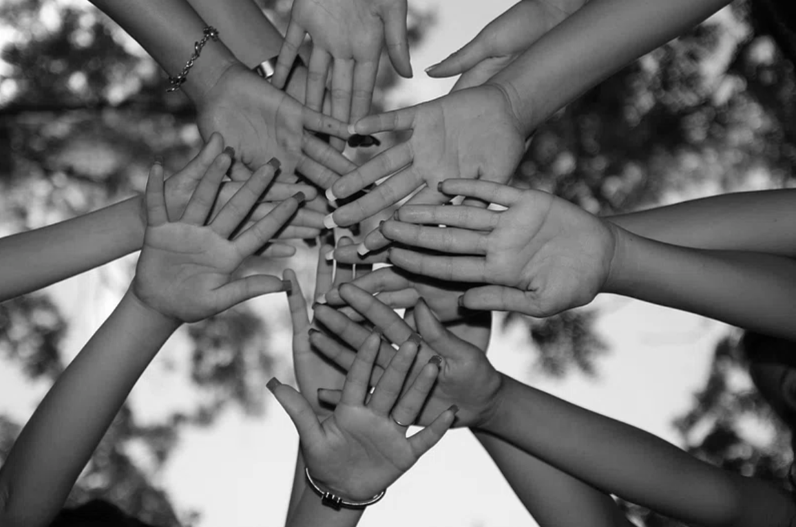 a black and white photo of hands together