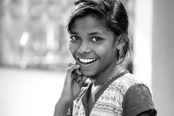 a black and white photo of an Indian girl smiling