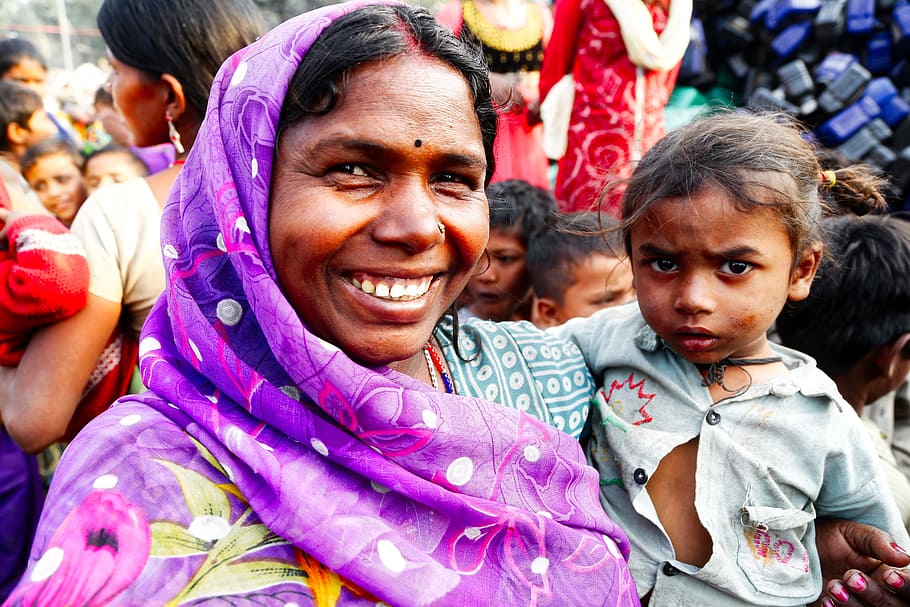 an Indian woman smiling and holding a baby girl
