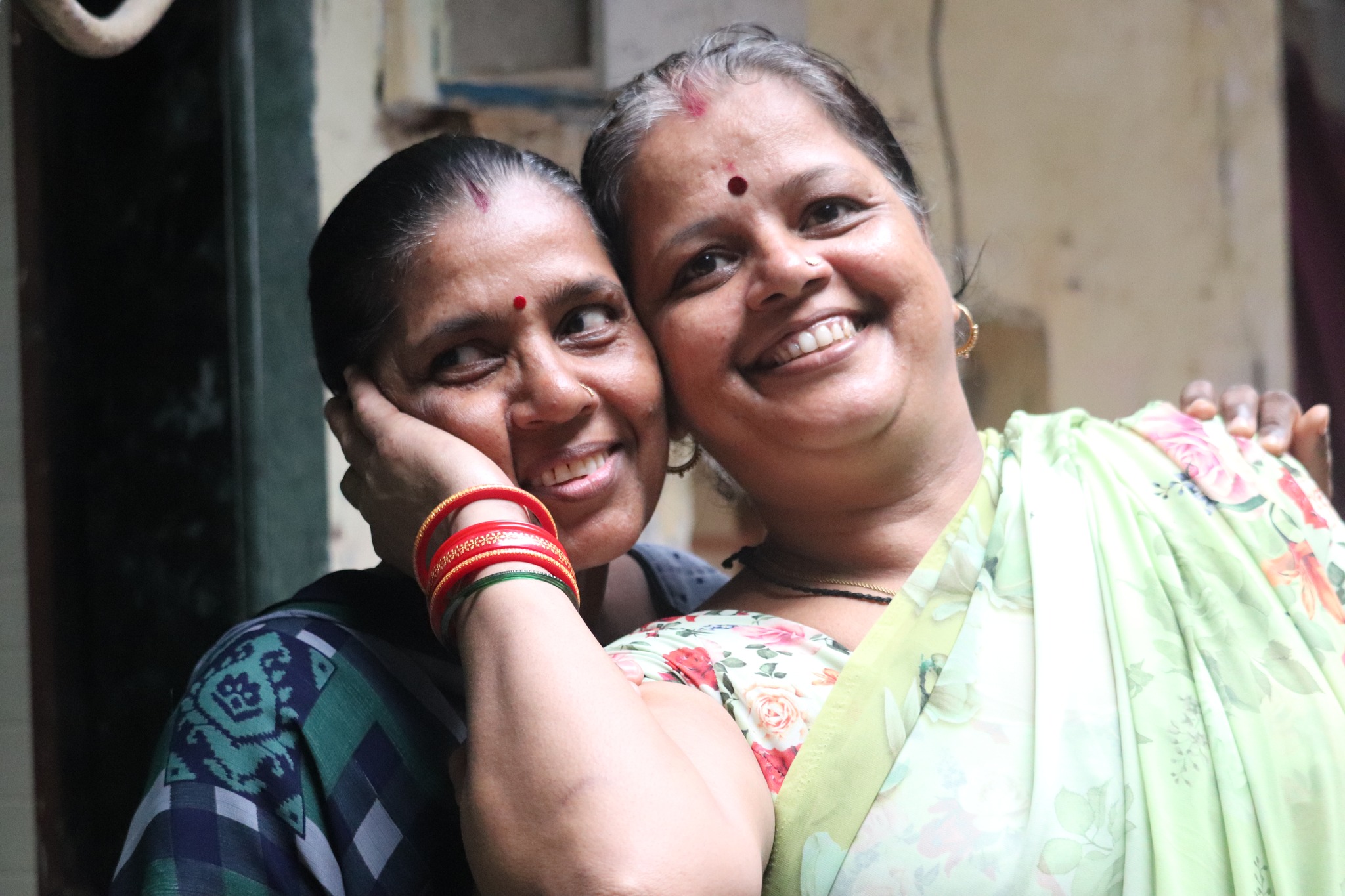 two women from the NGO SNEHA smiling