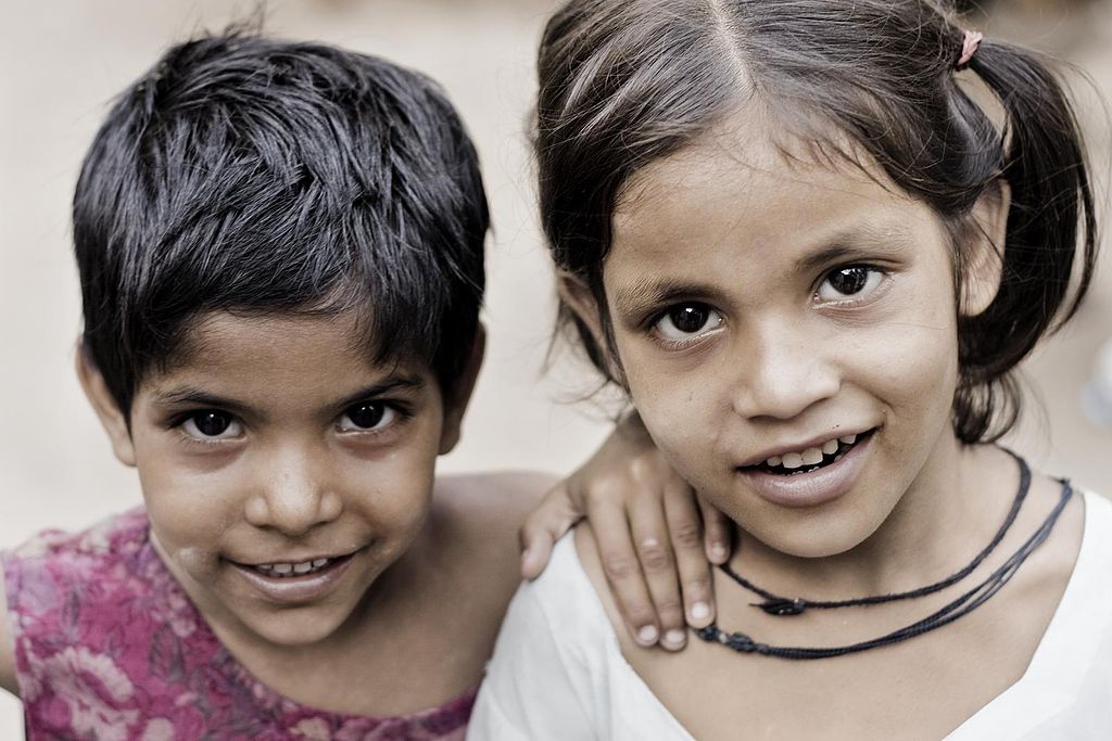 two Indian children smiling at the camera