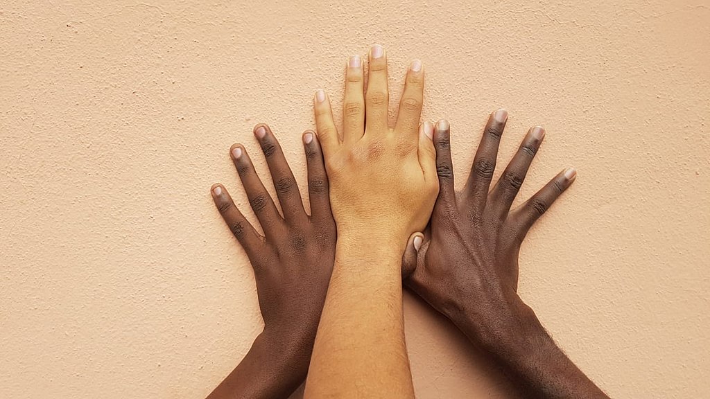three hands of different skin colors together