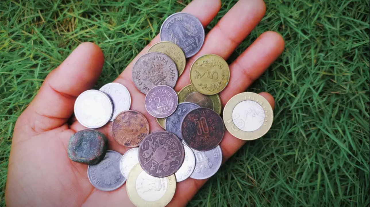 hand holding Indian coins