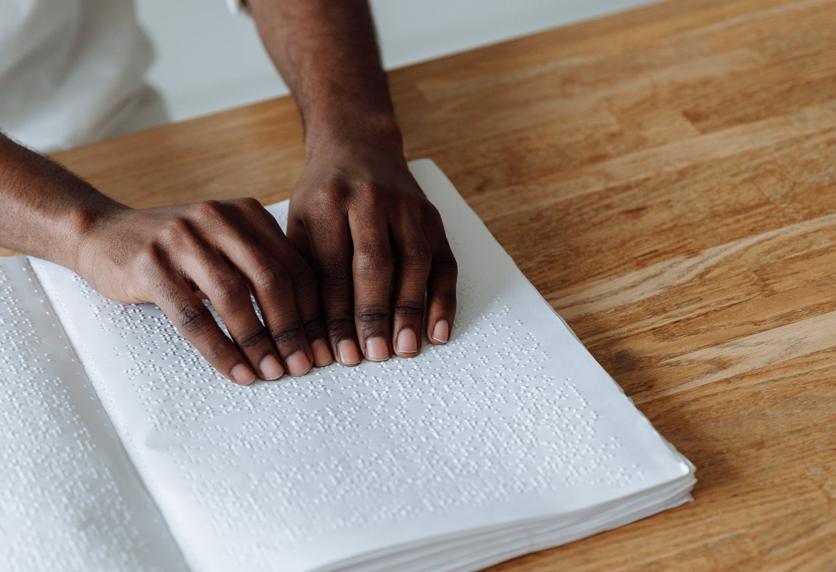 a pair of hands reading a book in Braille