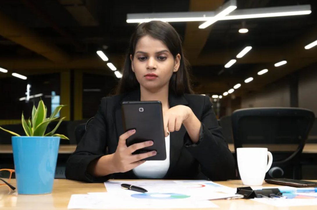 a young Indian woman looking at her tablet