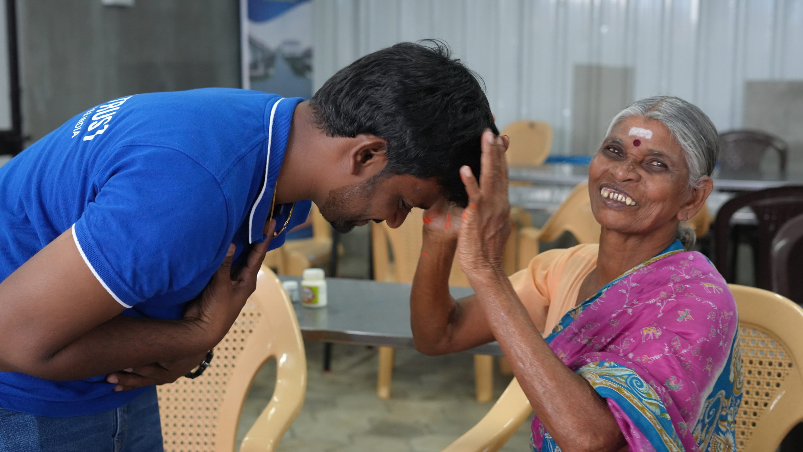 an elderly woman blessing a young man