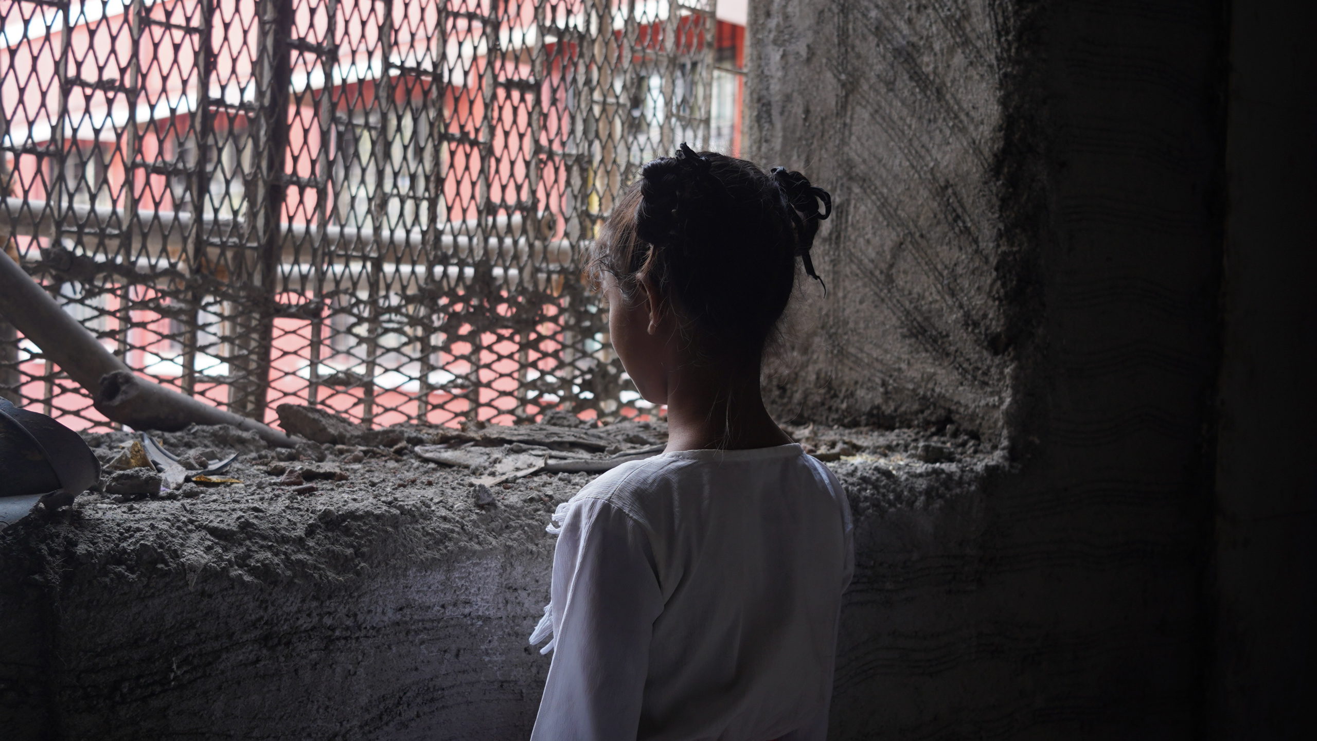 a child looking outside a dark window