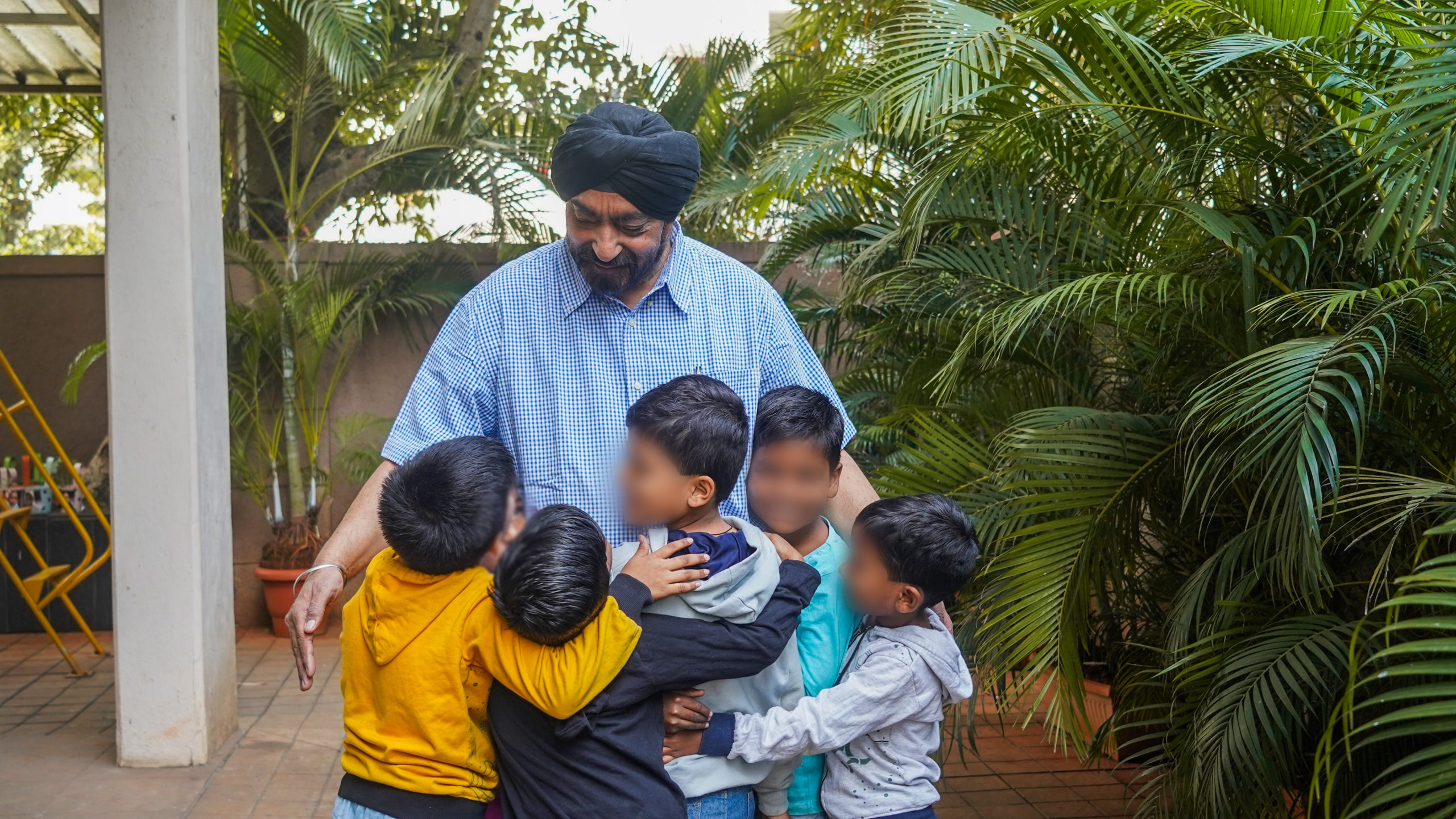 a man embracing a group of children outdoors