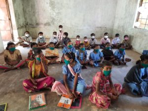 children with face masks sitting on the floor