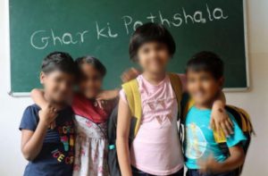 children standing against a chalkboard