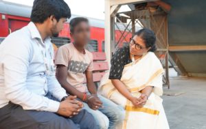 NGO staff with a child at a railway station