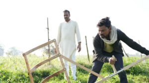 two farmers ploughing the field