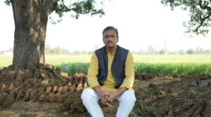 an NGO leader sitting in a field