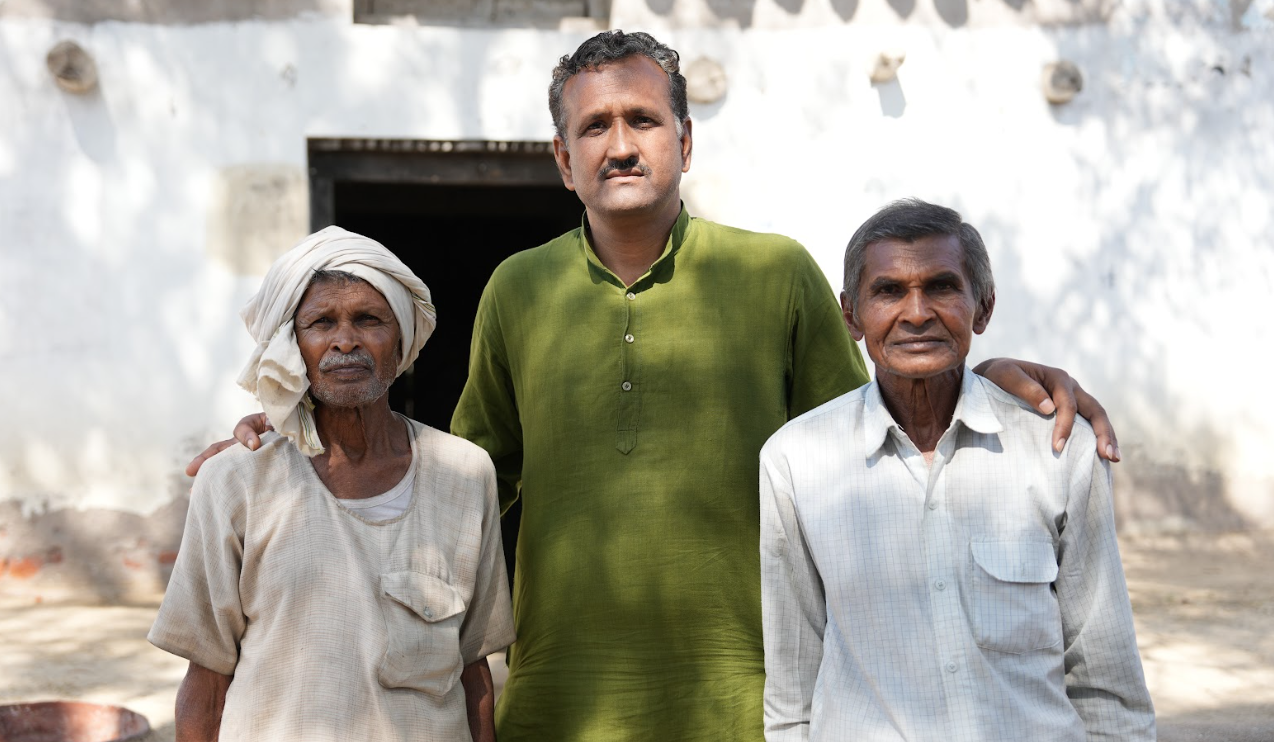 a man standing with two farmers