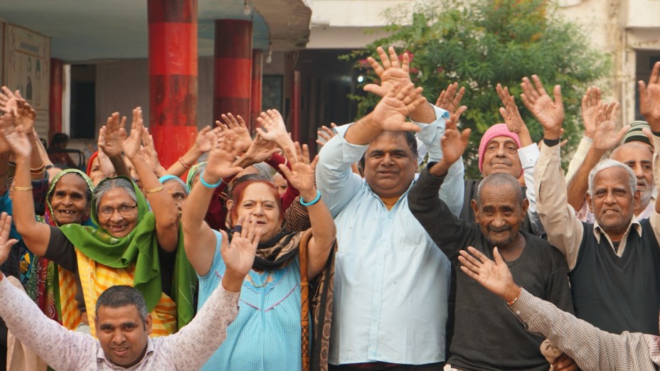 a group of elderly people waving at the camera