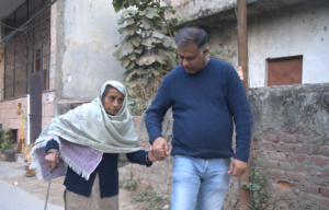 a man helping an elderly woman walk down the street