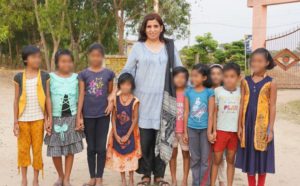 a woman standing with a group of children