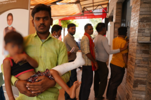 a man carrying a child with a broken leg
