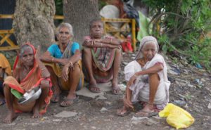 four poor women sitting on the ground