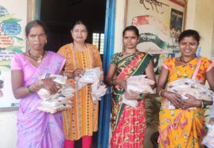 a group of women holding food grains