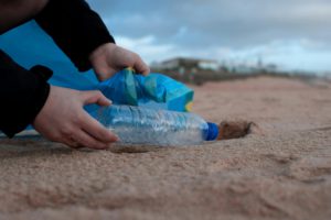 a person picking up trash at the beach