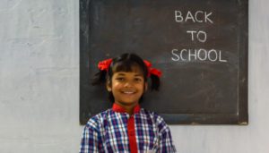 a student standing against a blackboard